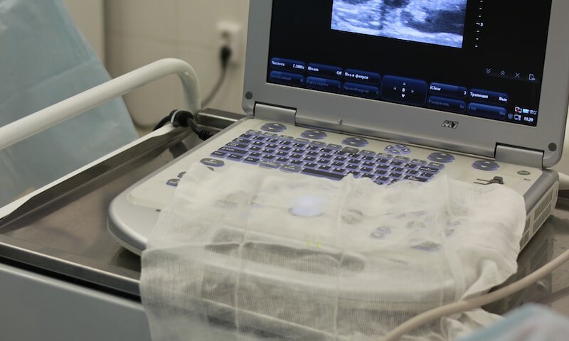 a laptop computer sitting on top of a hospital bed